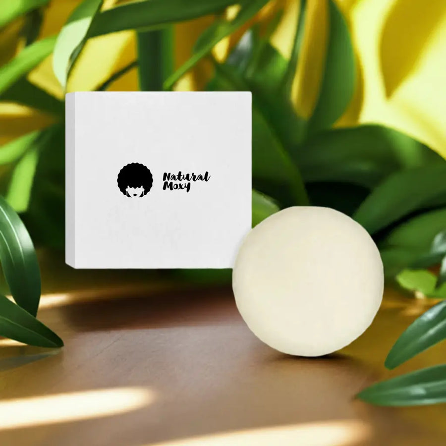 A close-up of a product presentation. 
A small, square, white box with a black graphic of a woman with an afro hairstyle and the words 